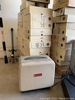 Beige Kodak slide machine in front of stacked cardboard boxes labeled for slides.