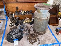 Overview of assortment: milk can, trivet, horseshoes, doorstop, hooks, figurines, tongs