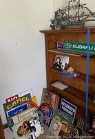 Assorted metal signs piled on floor leaning against shelf