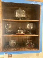 Wooden shelf displaying all seven clear glass serving pieces