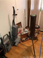 Overall view of vacuum, washboard, pitcher, basket, tripod rack and framed print
