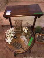 Rectangular wooden side table with dark finish, showing top surface and part of round side table below with decor.