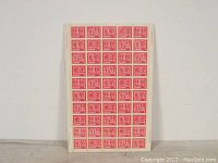 Full sheet of 50 red Canadian Winter Sports stamps on white paper, showing the entire sheet from an angle.