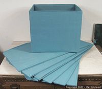 Set of 8 folded IKEA DRONA storage cubes laid out flat, with one fully assembled cube upright on top.