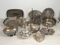 Lot of various silver-plated objects including trays, camel figurine, lidded jewelry box, incense holder, and small platters.