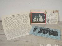 Overall view of the three items: envelope, typed sheet, and photo strip.