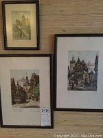 Three matted prints in simple black wood frames hung on wall