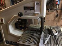 Full view of off-white Jet band saw showing blade, table and housing