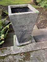 Front view of one planter showing overall shape and raised fern motif