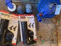 Blue fishing downrigger reel with counter, two heavy weights and two Scotty Rodmaster rod holders in original packaging.