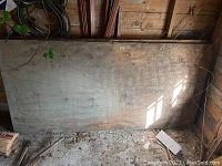 Wide view of stacked plywood sheets leaning against wall