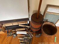Full lot overview showing butter churn, bucket, washboard, rolling pins, egg beaters and utensils