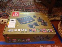 Box of Atari Flashback 8 Gold Deluxe gaming console showing console image and game titles with gold and red theme color.