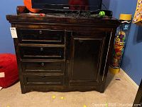 Front view showing four drawers on left and cabinet door on right, with visible scratches on top and dark wood finish.