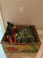 Box containing eleven Culinary Art decorative bottles and artificial greenery leaves, bottles are sealed with black caps, designs include food themes like red chili peppers and olives.