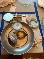 Top overview of all items in set including tray, tongs, cream and sugar bowls, forks, mirror, ashtrays