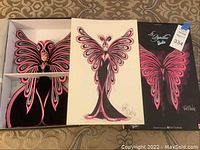 Barbie doll in butterfly-themed dress with signed poster inside box