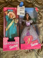 Photo of two boxed Barbie dolls side-by-side: Graduation Barbie on left, Princess Barbie on right.