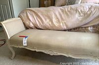 Side view of the bench showing upholstery, carved frame and legs