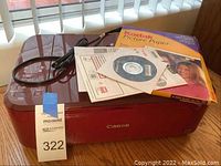 Canon PIXMA MG3620 printer with power cord, Kodak picture paper box, CD, and start-up guides on top of the printer.
