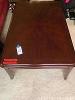 Top view of dark wood coffee table showing radial wood grain pattern and minor scratches