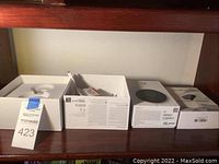 Overview of all boxed items on wooden shelf: Nest Cam Indoor, Nest Mini, LeFun transmitter