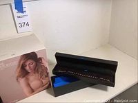 Close-up of red synthetic stone bracelet in black box, part of the lot.