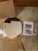 Stack of round mirror spheres including visible reflection and approximate 16 inch diameter with small pack of zip lock bags next to them.