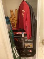 Photo shows USC tailgate wagon box, two sweatshirts hanging, foam pointer, and chair bags.