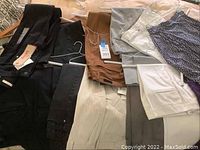 Photo showing a variety of women's pants, jeans and skirts laid out with some displaying tags.