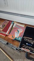 Stack of music books and open oboe case with instrument parts