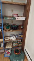 Shelf with multiple jigsaw puzzle boxes, baskets with shredded paper, and some holiday decorations.