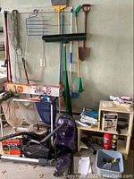 Photo of entire lot showing Kenmore and Oreck vacuums, mesh laundry separator, brooms, mops, vacuum bags, and cleaning supplies.