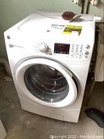 Front view of GE white front load washer showing door and control panel