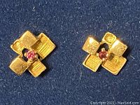 Front view of both earrings showing four-petal design and central rubies