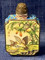 Front view showing hand painted birds and botanical elements with blue enamel accents on sides and ornate metal top.