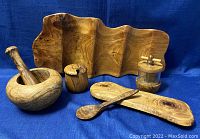 Set of wooden kitchen items on blue fabric background, showing natural wood grain and shapes.