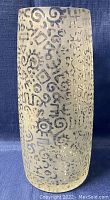 Front view of glass vase showing frosted finish with black abstract squiggles and symbols all around exterior surface.