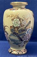 Front view of large oval crackle glazed vase with hand painted birds, flowers and gold accents on a cream background.