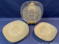 Six 7-inch dessert plates stacked and seven 8-inch luncheon plates stacked, both with textured bark pattern and square shape.