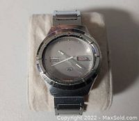 Front view of the Seiko watch showing the silver dial, 21 jewels marking, day and date display, and stainless steel case with minor scratches.