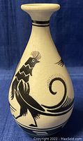 Front view of ceramic vase with black stylized bird design on white crackled glaze.