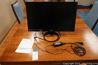 Acer 24-inch LCD monitor displayed on a wooden table with power cord, HDMI cable, and quick guide manual.