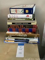 Stack of various books including The Surfer's Journal, cooking, travel, and history titles.