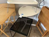 A group photo showing two folding wood trays in different wood tones, a white three-sided adjustable table, a black metal end table and a plastic tray