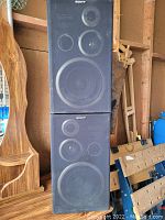 Front view of two black Sony SS-D115 speakers stacked vertically, showing the speaker drivers and Sony branding.