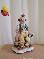 Hand painted porcelain clown figurine with balloons, detailed coloring, and bisque finish.