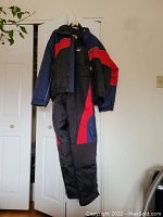Full view of men's Kamik winter suit showing jacket and pants with color block blue, red and black