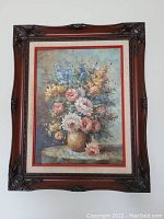Frontal view of oil painting showing detailed floral bouquet within ornate wooden frame.