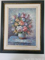 Framed oil painting on canvas of colorful floral bouquet in a vase.